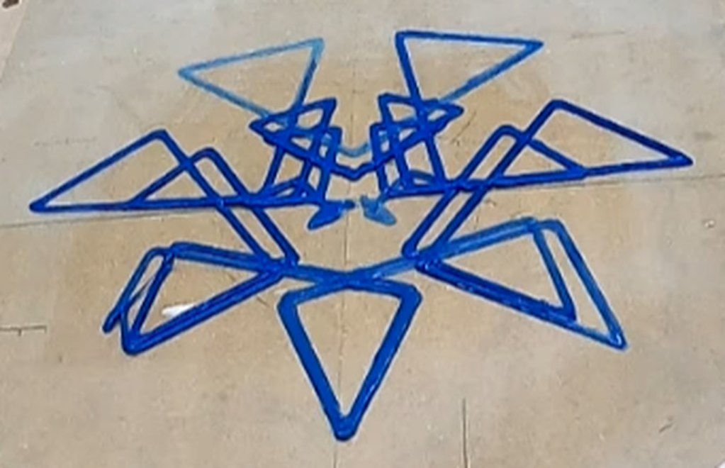 A star-pattern piece printed in blue on the workshop floor